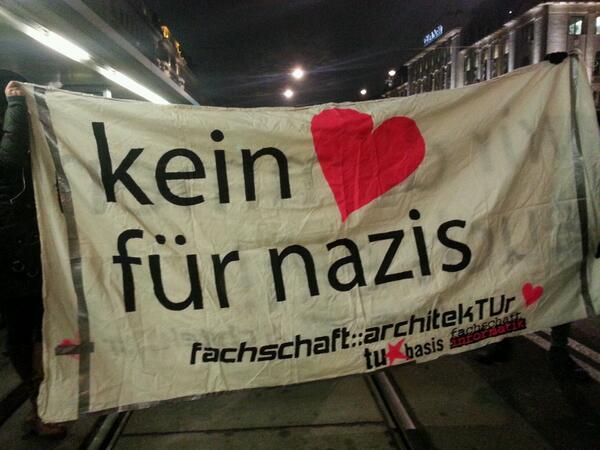 Foto eines Demo-Transparents. Unter dem Schriftzug "Kein <3 für Nazis" sind die Logos der Fachschaft Architektur, TU*Basis und Fachschaft Informatik zu sehen. Die Personen, die das Transparent hoch halten, sind nicht sichtbar.