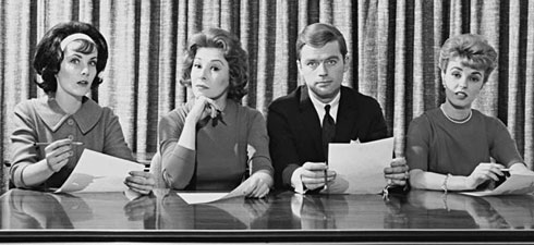 black and white photo of an exam board, 4 people sitting at a desk