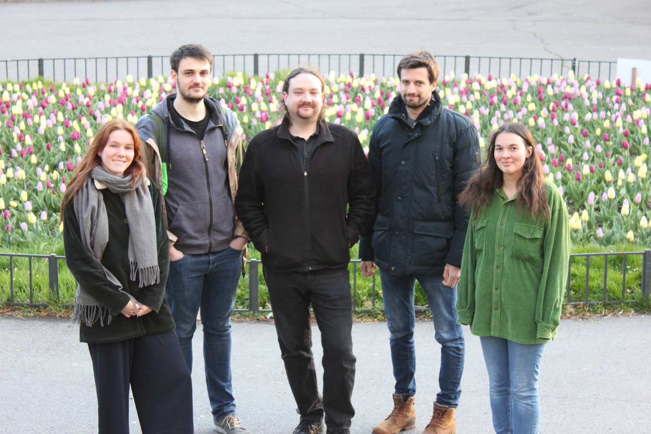 Gruppenfoto der Kandidat*innen: Iris, Alex, Jan, Anton, Alina vor einem Tulpenbeet stehend